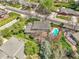 Aerial view showcases a backyard pool with mature trees, a deck, and nearby street at 6116 W Frost Dr, Littleton, CO 80128