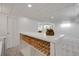 Stylish basement wet bar features ample wine storage and bright lighting at 6116 W Frost Dr, Littleton, CO 80128