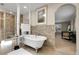 Bright bathroom features soaking tub with chrome feet, towel warmer, and large framed painting at 6116 W Frost Dr, Littleton, CO 80128