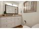 Bathroom features vanity, granite counter, framed mirror, and storage at 6116 W Frost Dr, Littleton, CO 80128
