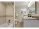 Light bathroom with shower and tub combination and a vanity sink with granite countertops at 6116 W Frost Dr, Littleton, CO 80128