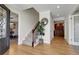 Welcoming foyer with hardwood floors, staircase, elegant mirror, and open view into the dining room at 6116 W Frost Dr, Littleton, CO 80128