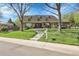 Charming brick home with mature trees, a well-manicured lawn, and inviting curb appeal in a quiet neighborhood at 6116 W Frost Dr, Littleton, CO 80128