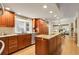 Spacious kitchen features wood cabinets, island with cooktop, granite counters, and stainless steel appliances at 6116 W Frost Dr, Littleton, CO 80128
