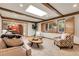 Living room with a skylight, fireplace, wood beams, and access to the kitchen at 6116 W Frost Dr, Littleton, CO 80128