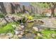 Close-up of the decorative pond with a waterfall, rocks, and greenery at 6116 W Frost Dr, Littleton, CO 80128