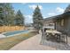 This backyard patio features outdoor dining, a partially covered swimming pool, and mature trees at 2616 S Leyden St, Denver, CO 80222