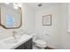 A stylish powder room featuring a modern sink, gold fixtures, and a decorative mirror at 2616 S Leyden St, Denver, CO 80222
