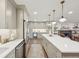A bright, modern kitchen featuring gray cabinets, a quartz island, a wine fridge, and stainless steel appliances at 2616 S Leyden St, Denver, CO 80222