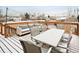 Snow covered back deck featuring a table and lounge seating with string lights overhead at 9240 W Wagon Trail Dr, Littleton, CO 80123