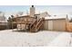 Rear view of the home displaying an elevated deck and access stairs at 9240 W Wagon Trail Dr, Littleton, CO 80123