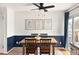 Dining room with a modern ceiling fan, wooden table, and white-and-blue wainscoting at 9240 W Wagon Trail Dr, Littleton, CO 80123