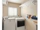 Functional laundry room featuring modern washer and dryer units, and convenient shelving at 9240 W Wagon Trail Dr, Littleton, CO 80123