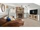 Cozy living room featuring a stone fireplace, plush seating, and a modern entertainment center at 9240 W Wagon Trail Dr, Littleton, CO 80123
