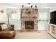 Cozy living room showcasing a stone fireplace and comfortable leather furniture at 9240 W Wagon Trail Dr, Littleton, CO 80123