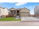Charming home featuring a covered porch, two-car garage, and manicured lawn at 2342 Shipman St, Brighton, CO 80603
