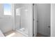 Bright bathroom featuring a shower with glass door and white tile surround at 2740 W 68Th Ave, Denver, CO 80221