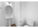 Bathroom with pedestal sink, toilet, and decorative mirror at 2740 W 68Th Ave, Denver, CO 80221
