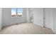 Bright, carpeted bedroom features a large window and an ensuite bathroom doorway at 2740 W 68Th Ave, Denver, CO 80221