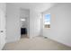 A carpeted bedroom features a window, closet, and doorway to an ensuite bathroom at 2740 W 68Th Ave, Denver, CO 80221