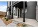Close up of a townhome front entrance featuring modern architectural details and manicured landscaping at 2740 W 68Th Ave, Denver, CO 80221
