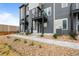 Attractive multi-story townhouse with stone accents, gray siding, and landscaped front yard at 2740 W 68Th Ave, Denver, CO 80221