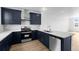 Modern kitchen features stainless steel appliances, white countertops, and stylish, navy blue cabinets at 2740 W 68Th Ave, Denver, CO 80221
