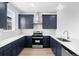 Modern kitchen featuring navy cabinets, quartz countertops and stainless steel appliances at 2740 W 68Th Ave, Denver, CO 80221