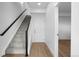Stairway with carpeted stairs, wooden railing, and a view into a well-lit room at 2740 W 68Th Ave, Denver, CO 80221
