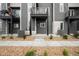 View of townhome featuring a covered entry, modern architecture, sidewalk, and rock landscaping at 2740 W 68Th Ave, Denver, CO 80221