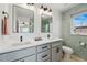 Stylish bathroom featuring double vanity, gray cabinets, and modern fixtures with hexagonal tile accent wall at 949 Raleigh St # 2, Denver, CO 80204