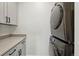 Functional laundry room boasts stackable washer/dryer and ample storage with modern cabinets and countertops at 949 Raleigh St # 2, Denver, CO 80204