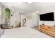 Bedroom featuring neutral tones, a large TV, and natural light from the balcony door at 8073 W 51St Pl # 303, Arvada, CO 80002