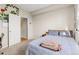 Bright bedroom featuring a bed, a bedside table, carpet flooring, and a white door at 8073 W 51St Pl # 303, Arvada, CO 80002