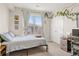 Well-lit bedroom with natural light, charming decor, and a view of the building across the street at 8073 W 51St Pl # 303, Arvada, CO 80002