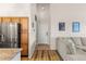 Entryway view featuring the front door, wood flooring, and stainless steel refrigerator in kitchen at 8073 W 51St Pl # 303, Arvada, CO 80002