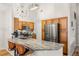 Bright kitchen with long granite countertops, stainless steel refrigerator, and modern lighting at 8073 W 51St Pl # 303, Arvada, CO 80002