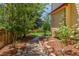 Landscaped yard with trees, a brick pathway, and mulched flowerbeds at 5168 Rocky Mountain Dr, Castle Rock, CO 80109