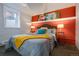 Cozy bedroom featuring warm orange accent wall, comfy bed, and bedside lamps at 1817 - 1821 Vine Vine St, Denver, CO 80206