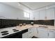 Compact kitchen with black and white hexagon backsplash, ample storage, and modern appliances at 1817 - 1821 Vine Vine St, Denver, CO 80206