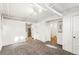 An open basement living area features neutral carpet and white walls leading to a kitchenette at 1422 Ivy St, Denver, CO 80220