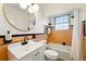 Updated bathroom with a round mirror, shower/tub combo, and colorful orange tile accents at 1422 Ivy St, Denver, CO 80220