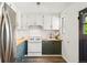 Efficient kitchen featuring a stainless steel refrigerator, butcher block countertops and bright white subway tile at 1422 Ivy St, Denver, CO 80220