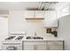 A well-lit kitchenette features a gas range and oven combo, plus light-colored cabinets and quartz countertops at 1422 Ivy St, Denver, CO 80220