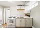 Compact kitchenette featuring white cabinets, gas range, subway tile backsplash, and stainless steel sink at 1422 Ivy St, Denver, CO 80220