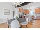 Dining area features a modern light fixture, updated stainless steel appliances, and hardwood floors at 8711 E Hampden Ave # 21, Denver, CO 80231