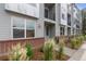 Modern townhome with gray siding, brick accents, and a well-maintained sidewalk at 8711 E Hampden Ave # 21, Denver, CO 80231
