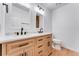 Bathroom with double sink vanity with wood cabinets, white counters and black hardware at 3600 S Pierce St # 1-104, Lakewood, CO 80235
