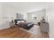 Stylishly furnished bedroom with wooden floors, white walls, gray bed and window at 3600 S Pierce St # 1-104, Lakewood, CO 80235