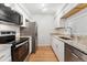 Modern kitchen with stainless steel appliances, granite countertops, and white cabinetry at 3600 S Pierce St # 1-104, Lakewood, CO 80235
